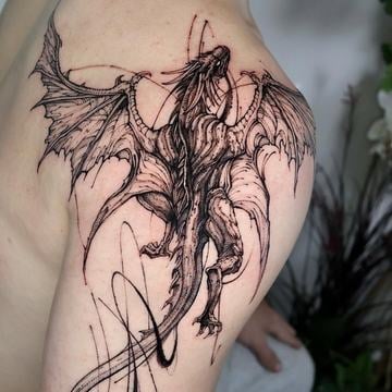 Evropský drak v blackwork stylu s roztaženými křídly na rameni a horní části paže; 