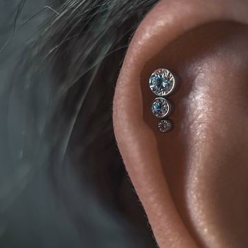 Piercing v horní části ucha s čistým a přesným provedením