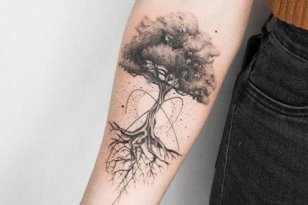 Jemné linework/blackwork tetování stromu s bohatou korunou a propletenými kořeny na vnitřním předloktí; dotwork stínování a tenké geometrické křivky, moderní a čitelné.