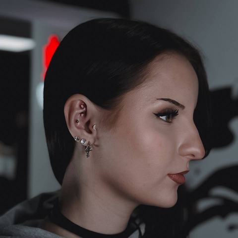Výrazná kombinace několika piercingů v uchu s drobnými stříbrnými šperky různých tvarů. Ozdoby rozmístěné podél chrupavky a ušního lalůčku vytvářejí zajímavou kompozici s lehce alternativním nádechem.