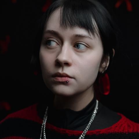 Drobné piercingy v uších s jemnými kovovými kroužky vytvářejí nenucenou a stylovou kombinaci. Jednoduché šperky decentně zvýrazňují ušní lalůčky a dodávají celkovému vzhledu osobitý, lehce alternativní charakter.
