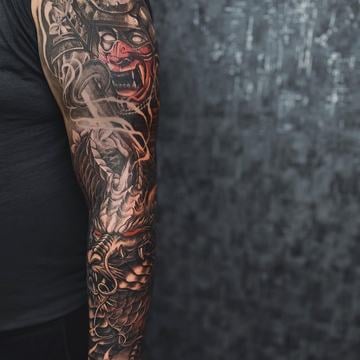 Černošedý realistický rukáv od ramene po zápěstí: japonsky inspirovaná oni maska s červeným akcentem, drak a kouřové prvky; precizní stínování a vysoký kontrast.
