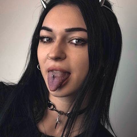 Piercing jazyka dodává výraznému stylingu hravý a provokativní detail. Kovový šperk podtrhuje temnou estetiku a sebevědomý výraz.