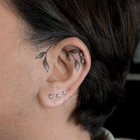 Tři drobné šperky vytvářejí čistou a jemně rytmickou kompozici. Minimalistický piercing krásně ladí s tetováním ucha.