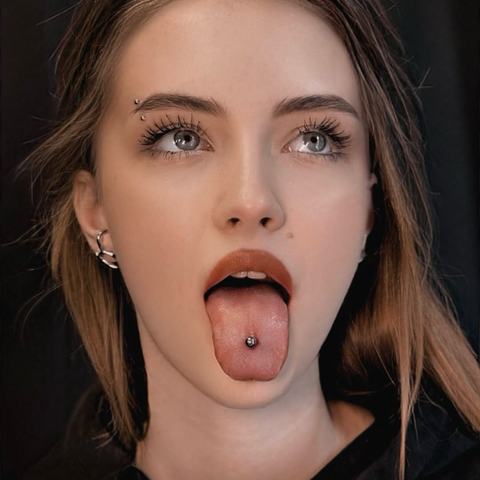 Piercing jazyka dodává vzhledu odvážný a hravý akcent. Jemný kovový šperk podtrhuje osobitý styl a přirozené sebevědomí.