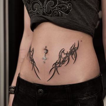 Břicho s tetováním bez viditelného piercingu