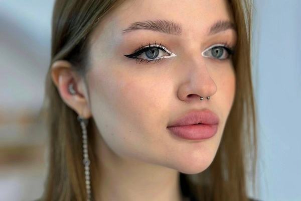 Portrét osoby se septum piercingem a náušnicí v uchu