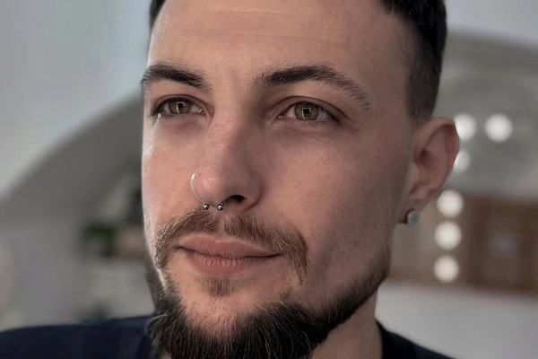 Detailní portrét osoby se septum piercingem a náušnicí v uchu